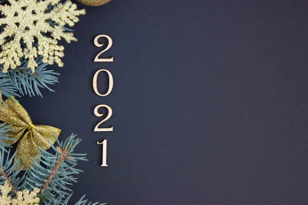 2021 yılbaşı kartı, yeni yıl süslemeleri altın Noel ağacı süslemeleri ve sol tarafta köknar dalları.