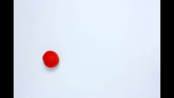 白いテーブルの上に赤いプラスチックボールが転がり 手でボールを押して心臓を作り バレンタインデーのコンセプトビデオテンプレート — ストック動画