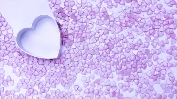 Stop-Motion-Animation Metall Herzform bewegt sich über rosa Bonbonherzen, Valentinstag-Konzept — Stockvideo