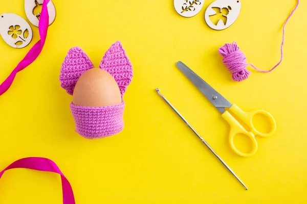 Dodać królika szydełkiem z uszami z przędzy, krok 15 DYI Pisanka w fioletowy kostium królika na szydełku na żółtym tle, koncepcja dekoracji na Wielkanoc, kreatywne dekoracje — Zdjęcie stockowe