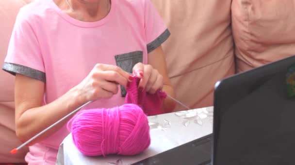 Mujer adulta mayor sosteniendo agujas tejiendo bufanda de punto relajante en el sofá. Senior señora madura anciana abuela manos femeninas haciendo artesanía trabajo a mano hobby concepto sentado en el sofá en casa — Vídeo de stock