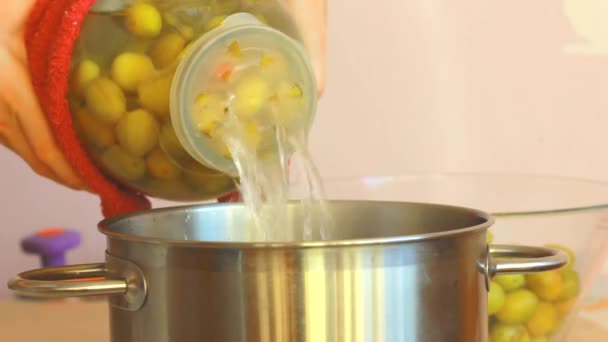 Syrop śliwkowy jest odprowadzany ze szklanego słoika, przygotowanie kompotu do przechowywania na zimę. — Wideo stockowe