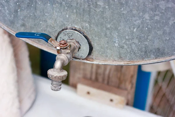 Grifo de metal con una válvula azul, lavabo en la calle en una casa de campo — Foto de Stock