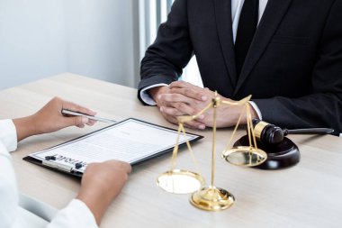 Bir erkek avukat ya da bir yargıç müvekkillerine yargı adaleti ve kovuşturma hakkında ölçekli danışmanlık yapıyor..