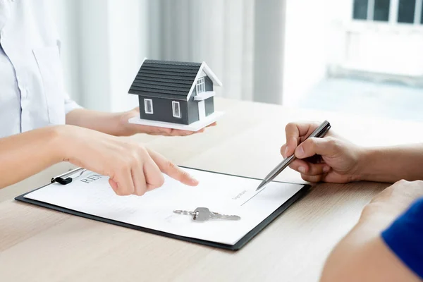 Kiralık evleri olan bir emlakçı ve müşteriler için ev kiralama sözleşmesi imzalayan bir emlakçı. Ev kiralama ve sigorta konsepti.