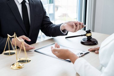 Bir erkek avukat ya da bir yargıç müvekkillerine yargı adaleti ve kovuşturma hakkında ölçekli danışmanlık yapıyor..