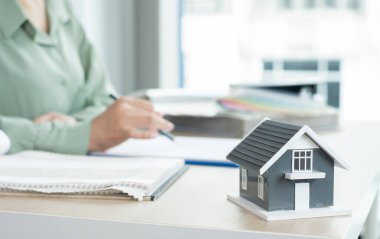 Tasarımcı evin içini planlıyor. Masasında örnek malzemeler olan yeni ev için mükemmel renkleri çiziyor ve seçiyor. Gayrimenkul tasarım işi fikirleri.