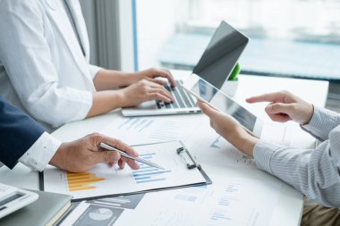 Üç iş adamı grafikler, finansal grafikler hakkında konuşuyor. Sonuçlar, planlama stratejilerini analiz ediyor ve hesaplıyor. İş başarısı oluşturma süreçleri..