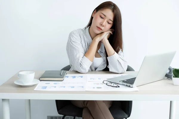 Working Asian women feel stressed, tired from work, migraine headaches from hard work while working at the office.