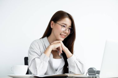 Video çağrısı, gözlüklü genç bir Asyalı kadın internetteki uzun mesafeli video ile iletişim kuruyor, dijital laptop ekranına bakıyor, bir arkadaşıyla mutlu bir şekilde selamlaşıyor..