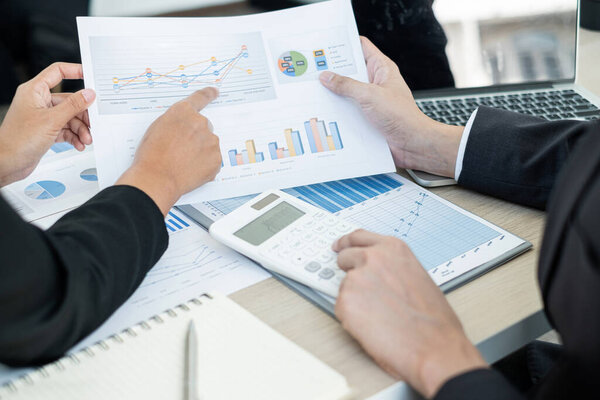 Two business leaders talk about charts, financial graphs showing results are analyzing and calculating planning strategies, business success building processes.