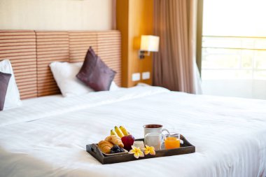 Meyveye odaklan. Meyveli bir otel odasında, VIP misafirlerin gelişini karşılamak için yatağın üzerine bir tepsi koyun..