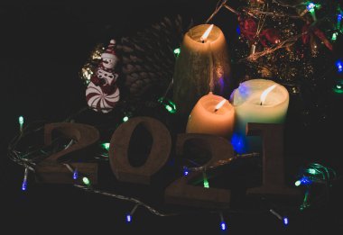 Yeni yıl arifesi, 2021 'i kabul etmelisin. Mumlar, Noel ağaçları ve yeni yıla hoş geldin partisi için parti ışıkları hazır olmalı..