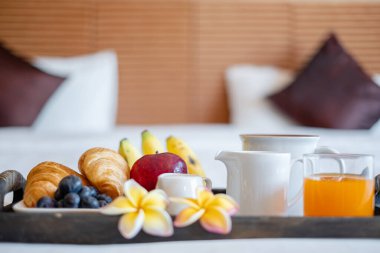 Meyveye odaklan. Meyveli bir otel odasında, VIP misafirlerin gelişini karşılamak için yatağın üzerine bir tepsi koyun..