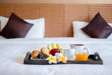 Meyveye odaklan. Meyveli bir otel odasında, VIP misafirlerin gelişini karşılamak için yatağın üzerine bir tepsi koyun..