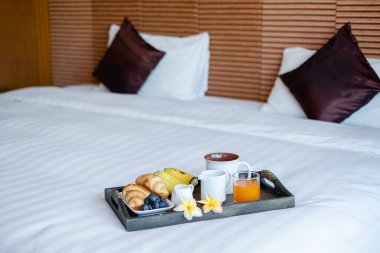 Meyveye odaklan. Meyveli bir otel odasında, VIP misafirlerin gelişini karşılamak için yatağın üzerine bir tepsi koyun..
