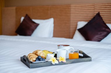 Meyveye odaklan. Meyveli bir otel odasında, VIP misafirlerin gelişini karşılamak için yatağın üzerine bir tepsi koyun..