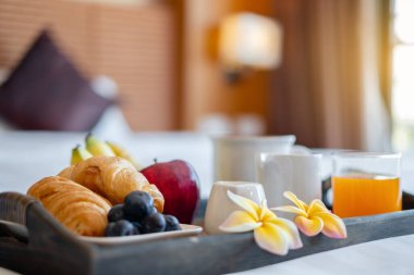 Meyveye odaklan. Meyveli bir otel odasında, VIP misafirlerin gelişini karşılamak için yatağın üzerine bir tepsi koyun..
