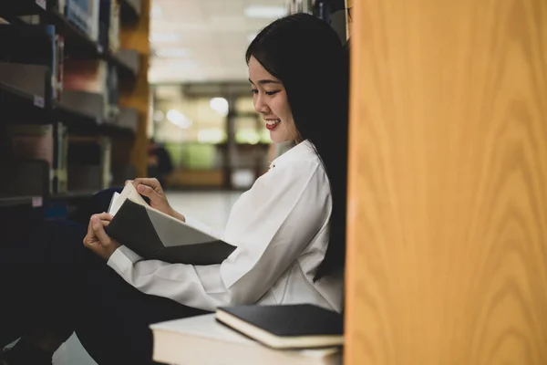 Young Asian women are searching for books and reading books on the tables and aisles of the college libraries to research and develop their academic and education self.