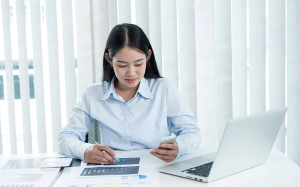 アジアの女性会計士は 彼らの机に座って 彼らの投資についての結果を示す財務グラフを計算し 成功したビジネス成長プロセスを計画する — ストック写真