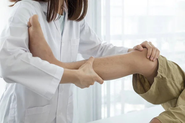 Erkek hastalar rehabilitasyon merkezlerinde muayene ve tedavi için diz ağrısı olan fizyoterapistlere danıştılar. Rehabilitasyon fizyoterapi konsepti.