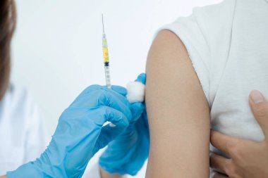 Kadın doktorlar hastanelerde, sağlık hizmetlerinde ve tıbbi konseptlerde salgın hastalıkları önlemek için şırıngalarla aşılandılar..