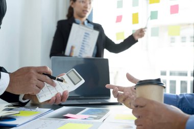 İş dünyası liderleriyle grafikler, finansal grafikler hakkında görüşmek, sonuçları gösteren planlama stratejilerini analiz etmek ve hesaplamak, iş başarısı oluşturma süreçlerini.