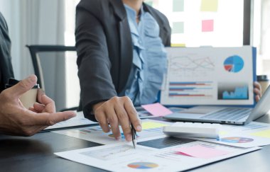 İş dünyası liderleriyle grafikler, finansal grafikler hakkında görüşmek, sonuçları gösteren planlama stratejilerini analiz etmek ve hesaplamak, iş başarısı oluşturma süreçlerini.