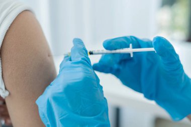 Kadın doktorlar hastanelerde, sağlık hizmetlerinde ve tıbbi konseptlerde salgın hastalıkları önlemek için şırıngalarla aşılandılar..