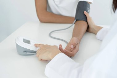 Kadın doktorlar kan basıncını ölçtü, hasta kalp atışlarını inceledi ve sağlık hizmetlerinden yakından bahsetti. Tıbbi ve sağlık hizmetleri kavramları.