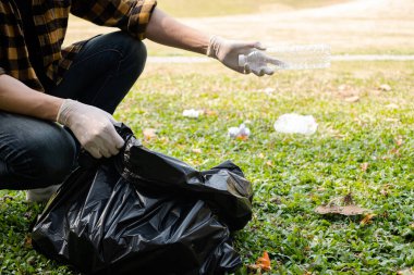 Adamın elleri plastik şişeleri topluyor, çöpleri siyah çöp torbalarına doldurup parkları temizliyor, kirlilikten kaçınıyor, çevreye ve ekosisteme dost oluyor..