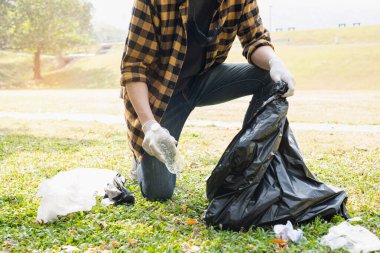 Adamın elleri plastik şişeleri topluyor, çöpleri siyah çöp torbalarına doldurup parkları temizliyor, kirlilikten kaçınıyor, çevreye ve ekosisteme dost oluyor..