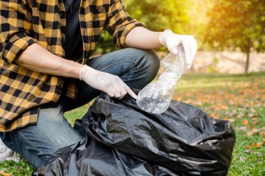 Adamın elleri plastik şişeleri topluyor, çöpleri siyah çöp torbalarına doldurup parkları temizliyor, kirlilikten kaçınıyor, çevreye ve ekosisteme dost oluyor..