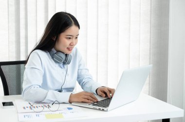 Asyalı kadın muhasebeci masalarında oturup yatırımlarıyla ilgili sonuçları gösteren mali grafikleri hesaplar ve başarılı bir iş büyüme süreci planlar..