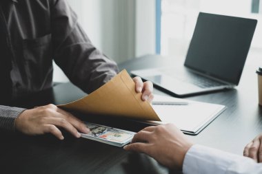 Yozlaşma. İş adamları para ile bir anlaşma yaptılar. Ortağına ofiste rüşvet teklif etti ve anlaşma altında bir sözleşme yaptı. Yasadışı para dolandırıcılığı Rüşvet ve yolsuzluk kavramı.