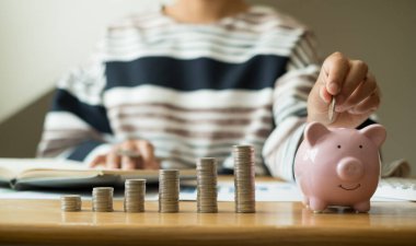 Kadın eli. Bozuk paralarla kumbaraya para koymak, madeni paralarla para biriktirmek, başarılı bir büyüyen işe girmek ve emeklilik için para biriktirmek. Emeklilik tasarruf kavramı.