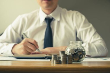 Man 's para biriktirmek, başarılı bir iş kurmak ve emeklilik için tasarruf yapmak için maddi grafikler hesaplıyor. Emeklilik Tasarruf kavramı.