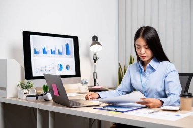 Asyalı kadınlar masalarında oturup yatırımlarıyla ilgili sonuçları gösteren mali grafikleri hesaplıyor ve başarılı bir iş büyüme süreci planlıyorlar..