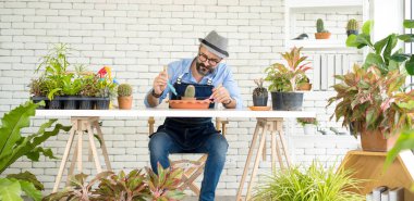 Bıyıklı, yaşlı ve yakışıklı bir adam ağaç bakımıyla mutlu olur. Evde bahçıvanlık hobisi. Emeklilikten sonra mutlu yaşamak. Doğa ve çevre kavramları.