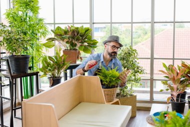 Bıyıklı, yaşlı ve yakışıklı bir adam ağaç bakımıyla mutlu olur. Evde bahçıvanlık hobisi. Emeklilikten sonra mutlu yaşamak. Doğa ve çevre kavramları.