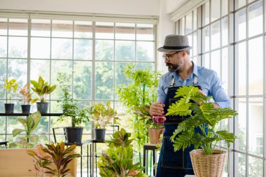 Bıyıklı, yaşlı ve yakışıklı bir adam ağaç bakımıyla mutlu olur. Evde bahçıvanlık hobisi. Emeklilikten sonra mutlu yaşamak. Doğa ve çevre kavramları.