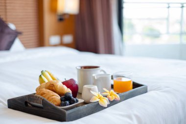Meyveye odaklan. Meyveli bir otel odasında, VIP misafirlerin gelişini karşılamak için yatağın üzerine bir tepsi koyun..