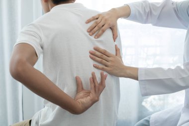 Kadın fizyoterapistler, rehabilitasyon merkezinde sırt masajı ve kas iyileşmesi için erkek hastalara fiziksel yardım sağlıyorlar..