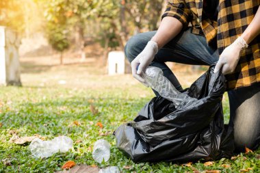 Adamın elleri plastik şişeleri topluyor, çöpleri siyah çöp torbalarına doldurup parkları temizliyor, kirlilikten kaçınıyor, çevreye ve ekosisteme dost oluyor..