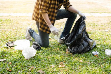 Adamın elleri plastik şişeleri topluyor, çöpleri siyah çöp torbalarına doldurup parkları temizliyor, kirlilikten kaçınıyor, çevreye ve ekosisteme dost oluyor..