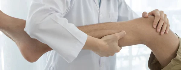 Erkek hastalar rehabilitasyon merkezlerinde muayene ve tedavi için diz ağrısı olan fizyoterapistlere danıştılar. Rehabilitasyon fizyoterapi konsepti.