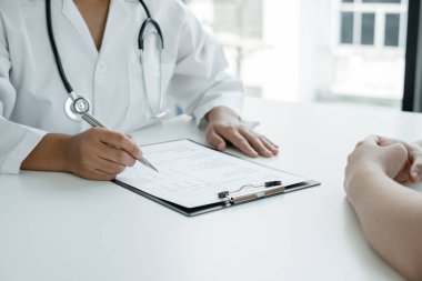 Kadın doktorlar, erkek bir hasta bir doktorla tanışıp hastalık sorunlarıyla ilgili sonuçlar aldıktan sonra tedavi önerirler. Tıbbi ve sağlık hizmetleri kavramları.