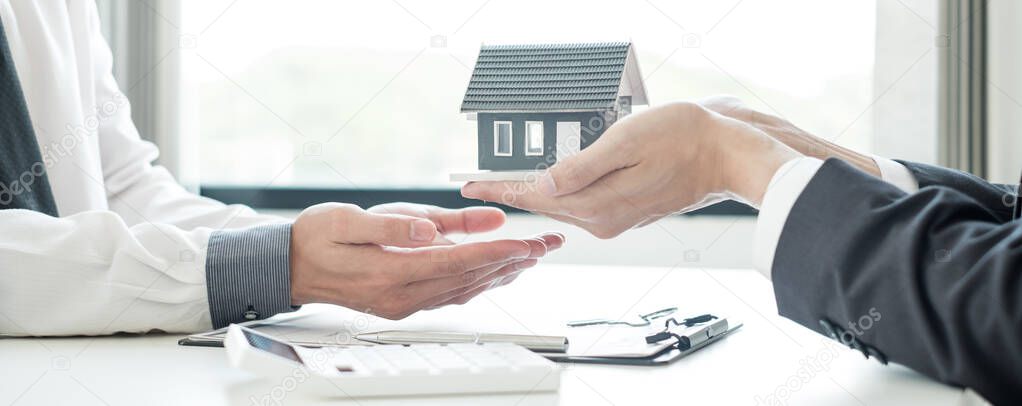 The real estate agent gives the house to a new owner's client after completing the signing of the lease and formally completing home insurance. Rental and insurance concepts.