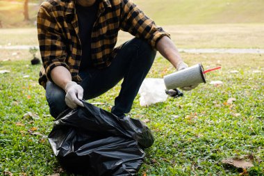 Adamın elleri plastik şişeleri topluyor, çöpleri siyah çöp torbalarına doldurup parkları temizliyor, kirlilikten kaçınıyor, çevreye ve ekosisteme dost oluyor..