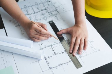 İnşaatta çalışan mimarlar ya da mühendisler inşaat planları, baskı, inşaat sahalarında yazılar çiziyor. Ev tasarımı kavramı.